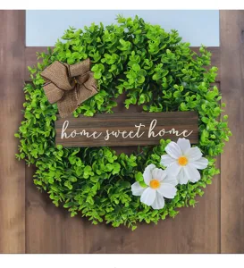 Green eucalyptus leaf wreath with Home Sweet Home wooden sign on a brown door