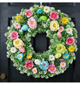 Detailansicht eines lebhaften künstlichen Osterkranzes mit bunten Eiern und Blumen.