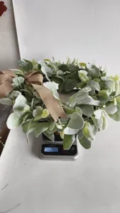 Close-up view of an artificial lamb's ear greenery wreath weighing 290g on a digital scale