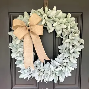 Close-up detail of a faux lamb's ear leaf wreath with a rustic burlap bow decoration.