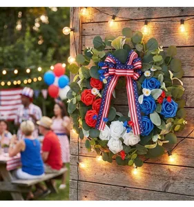 Beautiful Independence Day wreath hanging on a rustic wooden wall with warm string lights.