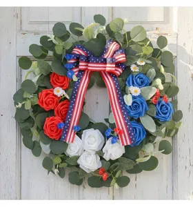 Detailed view of Independence Day wreath with red, white, and blue roses and American flag bow.