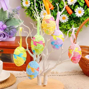 Adornos de huevos de Pascua de espuma de colores colgados en un árbol decorativo blanco.