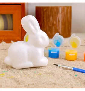 Detailansicht einer weißen DIY-Osterhasenfigur aus Schaumstoff mit Farbtöpfen und Pinsel