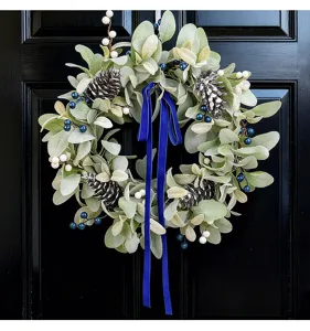 Detail of lamb's ear wreath with artificial pine cones, blue berries and velvet ribbon
