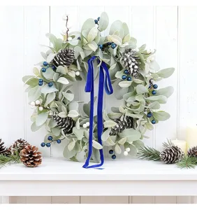 Staging of a simulation lamb's ear wreath with pine cones and a blue velvet ribbon