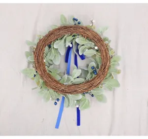 Detail shot of the artificial rabbit ear grass wreath with blue berries and ribbons