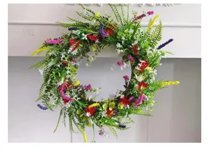 Gedetailleerd uitzicht op de kleurrijke kunstmatige veldbloemenkrans voor de voordeur.