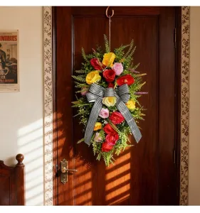 Vista detallada de guirnalda de rosas artificiales con un lazo de rayas colgado en madera.