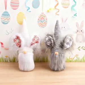 Pair of cute handmade Easter faceless gnome dolls with rabbit ears on a wooden table