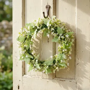Couronne de jardin rustique printemps-été avec fleurs blanches et eucalyptus sur porte