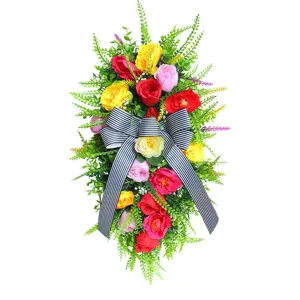 Corona de flores artificiales para puerta con un gran lazo de rayas blancas y negras
