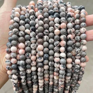 Close-up of natural pink and grey zebra stone round loose beads for DIY jewelry