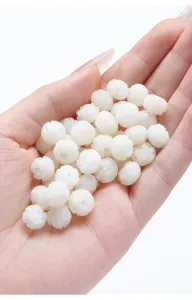 Close-up view of hand-carved white jade bodhi root lotus beads for DIY jewelry making.