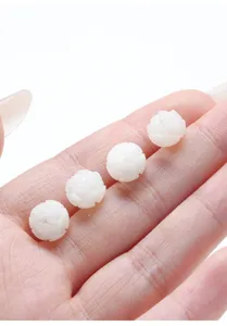 Close-up of four white carved lotus beads made from natural bodhi root