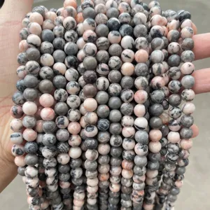 Detailed close-up showing texture of natural zebra stone round beads in pink and grey