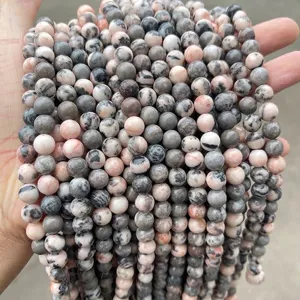 Close-up of natural pink and grey zebra jasper round loose beads for jewelry making