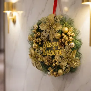 Luxury golden Christmas wreath with artificial pine branches and Merry Christmas sign.