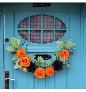 Handcrafted Halloween wreath detail with orange roses, pumpkins, and black accents on a door