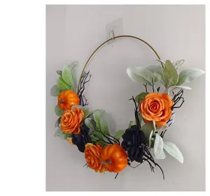 Halloween wreath with orange pumpkins and roses on an iron hoop for wall decoration