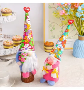 Close-up of two festive gnome dolls with floral hats and red love heart toppers