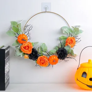 Decorative Halloween artificial pumpkin and orange rose wreath on gold iron ring