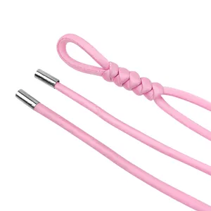 Close-up of pink round rope belt featuring metallic aglets and fine texture detail