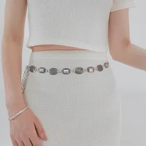 Elegant bohemian silver metal waist chain accessory styled on a white knit outfit