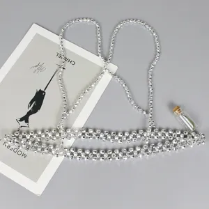 Detailed close-up of a stylish silver beaded harness waist chain belt for fashion.