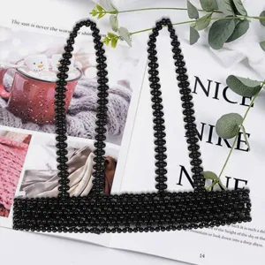 Detailed view of black beaded harness belt with suspender straps on magazine