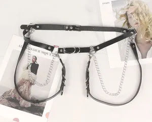 Dettaglio dell'imbracatura punk gothic in pelle con catene d'argento e fibbie a cuore.