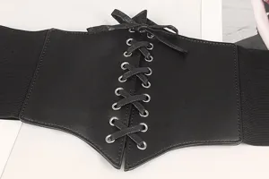 Détail d'une ceinture corset noire à lacets avec bande élastique et œillets en argent