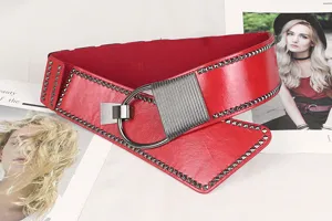 Close-up of a red studded punk style wide elastic belt with a metal ring buckle