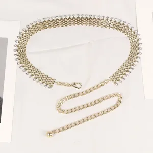 Detail view of gold metal waist chain belt with sparkling rhinestones for dresses