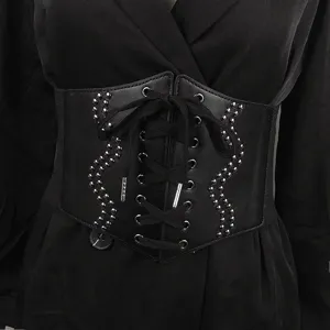 Gros plan d'une large ceinture corset noire à lacets avec des motifs décoratifs cloutés