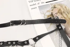 Dettaglio di un'imbracatura gotica punk in pelle nera con fibbie e anelli in metallo