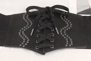 Vue détaillée de la large ceinture corset noire avec laçage et accents de rivets