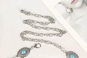 Detailed macro view of silver metal chain belt featuring oval turquoise stone medallions