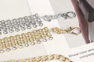 Close-up detail of stylish metal waist chains with sparkling rhinestones and lobster clasps