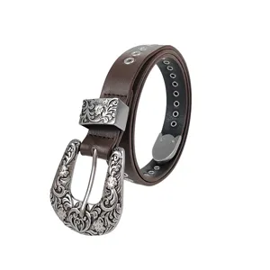 Detail showing the ornate carved silver buckle on a y2k punk style brown leather belt