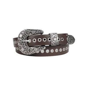 Detail of vintage Y2K brown belt with ornate silver buckle and metal grommets.