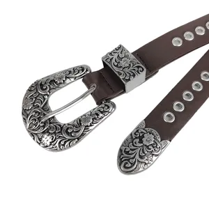 Close-up detail of Y2K punk style brown leather belt with vintage floral carved buckle