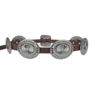 Detailed view of Western boho wide belt with ornate silver metal conchos and brown leather.