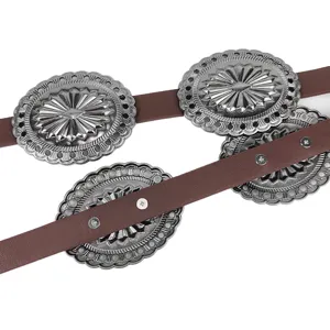 Macro view of vintage Western leather belt featuring carved silver sunburst conchos