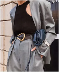 Gros plan d'une ceinture pour femme avec une grande boucle en métal doré en forme de U
