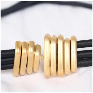 Close-up macro view of the gold metal ring buckle on a vintage black caterpillar elastic belt