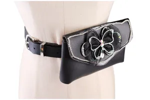 Detailed view of black belt bag with sparkling rhinestone butterfly decoration on a mannequin