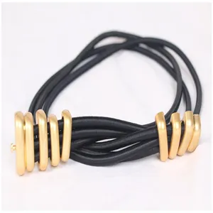 Detailed view of a retro black elastic waist belt with elegant gold-tone metal rings