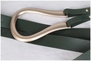 Vue détaillée d'une grande boucle métallique en U dorée mate sur une ceinture verte.