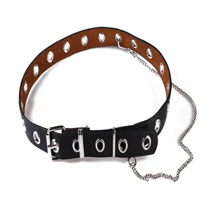 Macro detail of a black punk style wide belt featuring silver eyelets and a metal chain